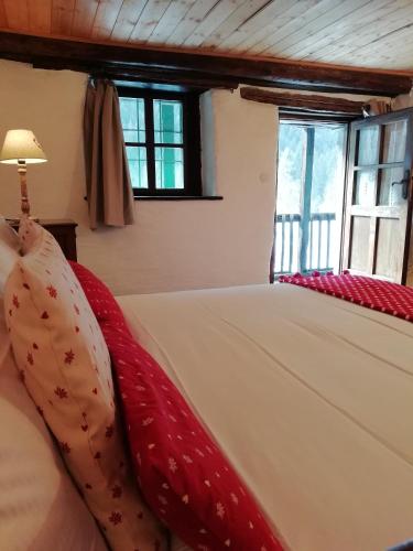 a bedroom with a bed with a red blanket at Chalet Case delle lobbie in Ceppo Morelli