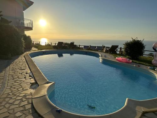ein großer Swimmingpool mit dem Meer im Hintergrund in der Unterkunft villa incanto in Zambrone
