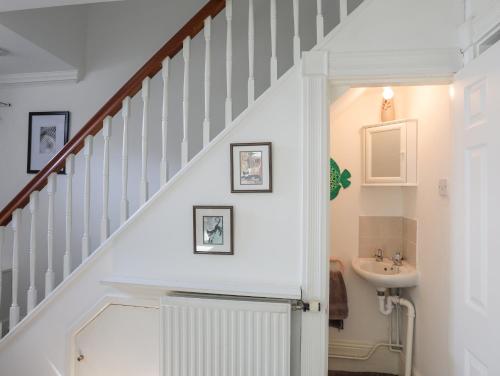 a bathroom with a staircase with a sink and a stair case at Sea View Cottage in Menai Bridge