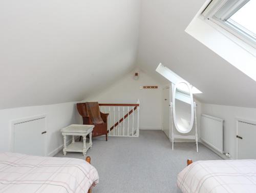 a attic bedroom with two beds and a window at Sea View Cottage in Menai Bridge