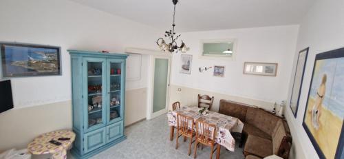 a dining room with a table and a blue cabinet at Casa Vacanza Lidoconchiglie in Lido Conchiglia