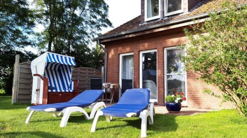 クルムホルンにあるWohnung in Pilsum mit Eigener Terrasseの家の外に座る青と白の椅子2脚