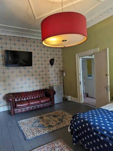 a living room with a couch and a red lamp at Caspian Hotel in London