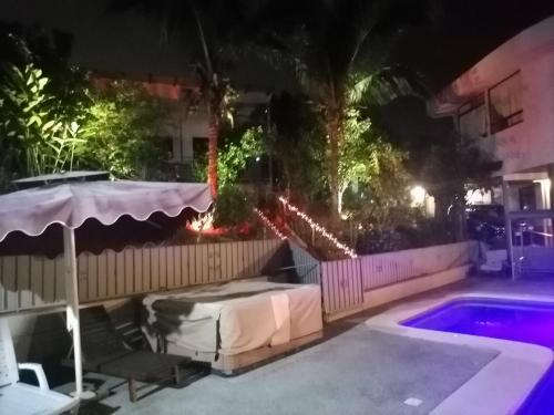 a backyard with a bed and a swimming pool at night at Villa Garita Inn in La Garita