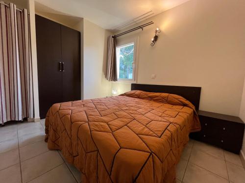 une chambre avec un lit dans une pièce avec une fenêtre dans l'établissement Mini Villa 63 proche plage dans résidence avec piscine à Favone, à Sari-Solenzara