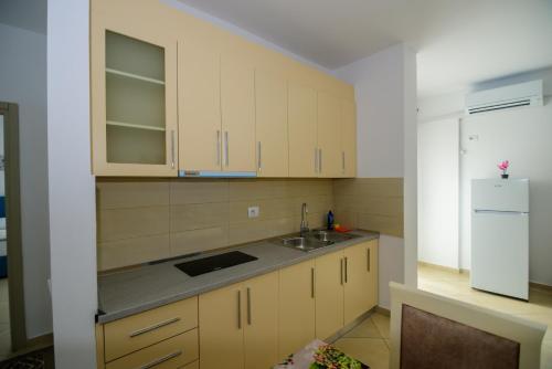 a kitchen with a sink and a refrigerator at Harris&Arvien Apartment's in Vlorë