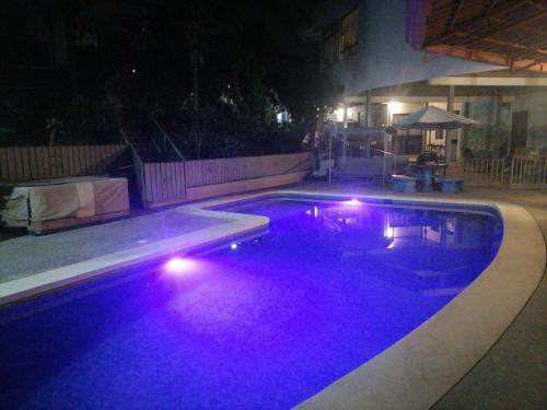 a swimming pool at night with purple lights in it at Villa Garita Inn in La Garita