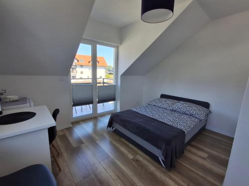 um quarto com uma cama, um lavatório e uma janela em Kompas em Krynica Morska