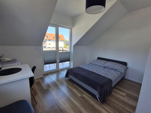 1 dormitorio con cama, lavabo y ventana en Kompas, en Krynica Morska