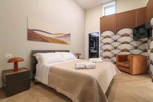 a bedroom with a large bed and a chair at Dimora Gioia in Ercolano