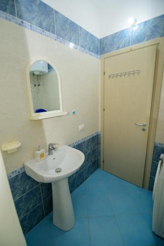 a bathroom with a white sink and a mirror at Harris&Arvien Apartment's in Vlorë