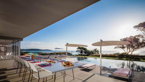 an outdoor patio with a table and chairs and a swimming pool at Amamia in Saint-Tropez