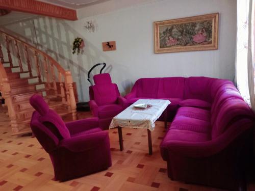 una sala de estar con un sofá púrpura y sillas en Guli, en Gori
