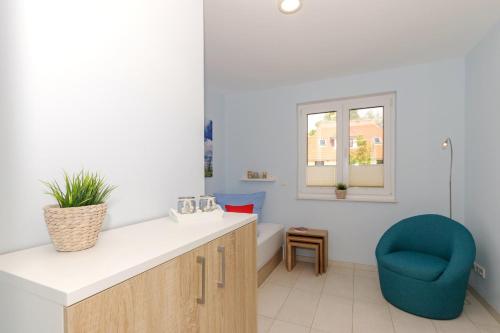 baño con lavabo y silla azul en Residenz Blinkfueer Whg_ 6 _Poseid, en Rerik