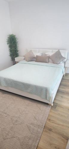 uma cama num quarto branco com um tapete em מול הים בקיסריה em Caesarea