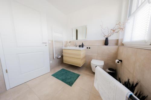 a bathroom with a white sink and a toilet at Haus Q Superior - Hälfte 1 in Zingst