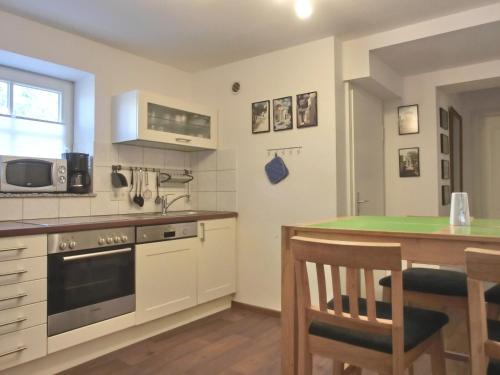 kuchnia ze stołem i kuchenką górny piekarnik w obiekcie Ferienwohnung MH3 "Summer Breeze" w mieście Rostock