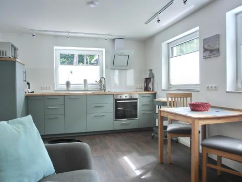 a kitchen with green cabinets and a table and a table sidx sidx sidx at Ferienwohnung MH1 "Blue Ocean" in Rostock