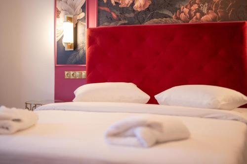 two beds with a red headboard in a room at L Suites The Writer's House in Gythio