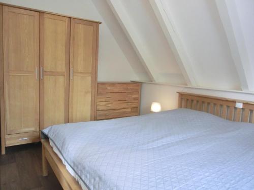 een slaapkamer met een bed en houten kasten bij Ferienwohnung MH2 "Sunrise" in Rostock