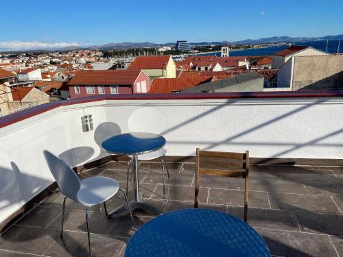 een balkon met 2 stoelen en een tafel op een dak bij Charmante Wohnung in Vodice mit Schöner Terrasse - b61717 in Vodice