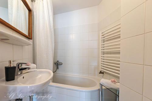 a white bathroom with a sink and a tub at Fewo Jaisweg in Mittenwald