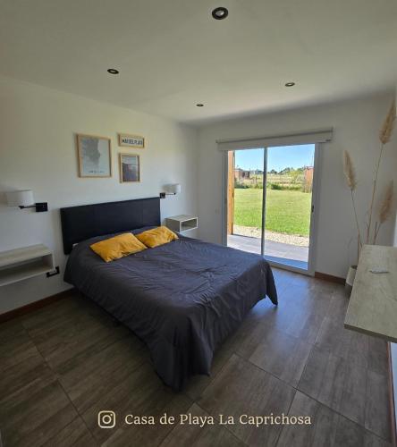 a bedroom with a bed and a sliding glass door at La Caprichosa Chapadmalal in Chapadmalal