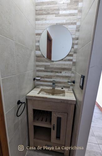 a bathroom with a sink and a mirror at La Caprichosa Chapadmalal in Chapadmalal