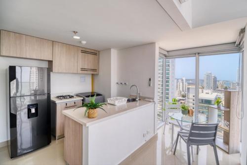 a kitchen with a counter and a table with chairs at Luxury Sea View Duplex in the Heart of the City in Cartagena de Indias