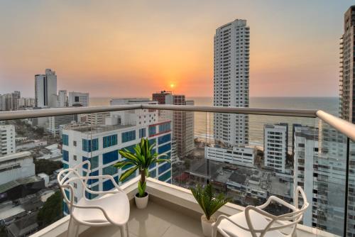 a balcony with chairs and a view of the city at Luxury Sea View Duplex in the Heart of the City in Cartagena de Indias