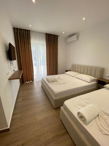a hotel room with two beds and a television at Vila Beqja in Durrës