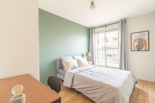 une chambre avec un lit, une table et une fenêtre dans l'établissement Charmant appartement à Nice, à Nice