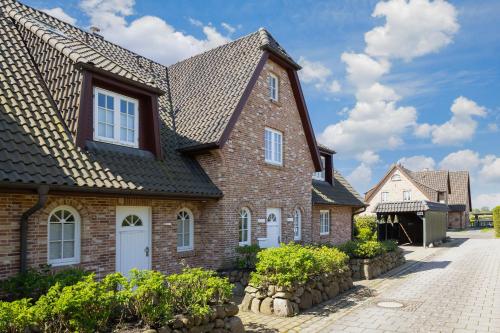 a brick house with a shingled roof at Haus Strandlaeufer in Keitum
