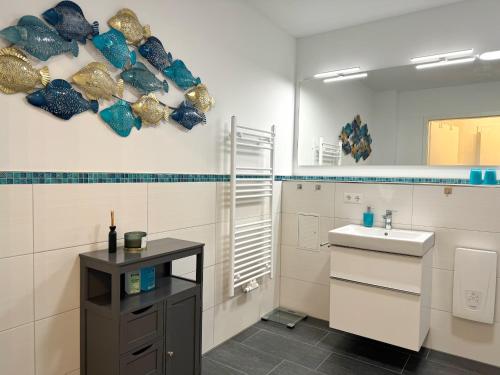 a white bathroom with a sink and a mirror at Ferienappartement Balve in Sassnitz