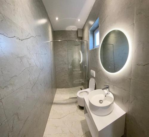 uma casa de banho com um WC, um lavatório e um espelho. em Vila Beqja em Durrës