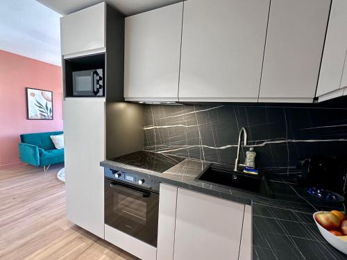 une cuisine avec des armoires blanches et un évier dans l'établissement Charmant appartement à Nice, à Nice