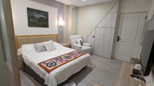a bedroom with a bed and a chair in it at 182 Heguangju in Hung-i-li