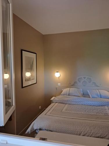 - une chambre avec un lit et deux lumières sur le mur dans l'établissement 2 pièces avec piscine chauffée, à Deauville