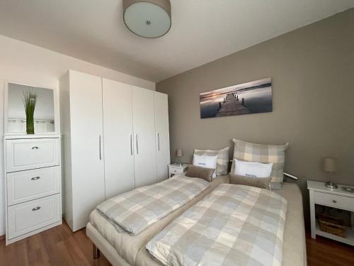 1 dormitorio con 1 cama y reloj en la pared en Seeschlösschen App 124, en Grömitz