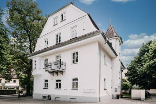 a white building with a balcony on the side at Privat-Gästezimmer LA-Villa-Feeling in Landshut