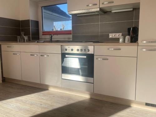 a kitchen with white cabinets and an oven at Immensee App D in Ehst