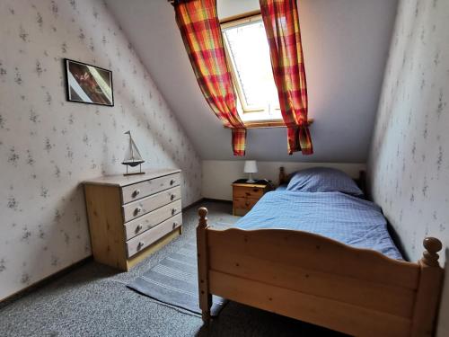 - une chambre avec un lit, une fenêtre et une commode dans l'établissement FHKlützke Deichblick, à Kating
