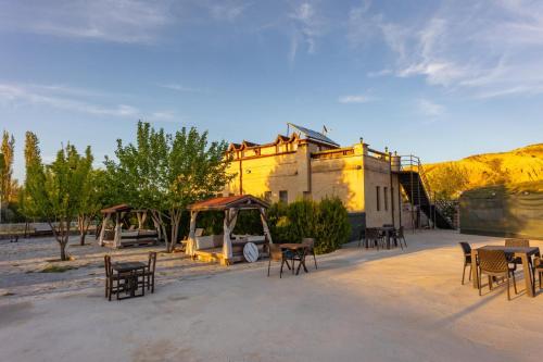 a group of tables and chairs in front of a building at Cappadocia Cave Sinasos in Nevşehir