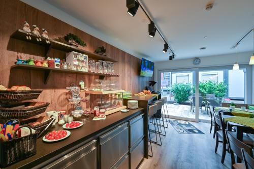 a restaurant with a counter with food on it at Hotel Gästehaus Stock Zimmer Wasserfall in Friedrichshafen