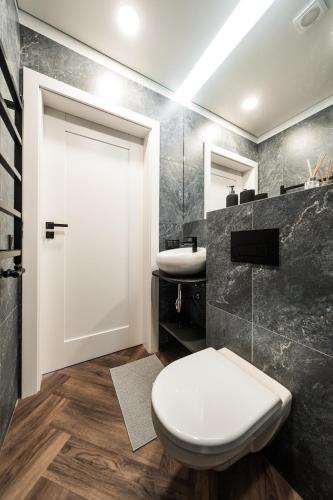a bathroom with a toilet and two sinks at Riverra House - Studio Panorama View in Kaunas