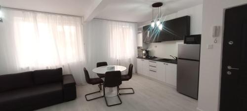 een keuken met een tafel en stoelen in een kamer bij Apartament Central in Tulcea