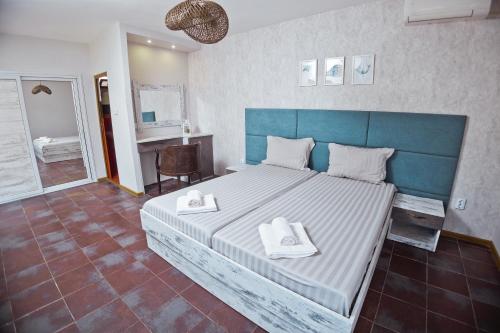 a bedroom with a large bed with two towels on it at Хотел и Вили Марая apartament in Tsarevo