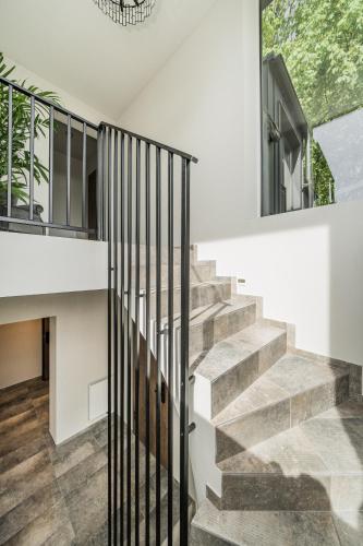 a staircase in a house with white walls and concrete stairs at Riverra House - Studio Panorama View in Kaunas