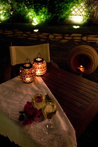 a table with two glasses of wine and candles on it at Oasis Beach Hotel in Skala