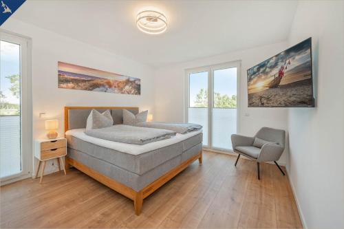 1 dormitorio con 1 cama y 1 silla en An der Haffküste Ferienwohnung Heimat Hafen en Zirchow